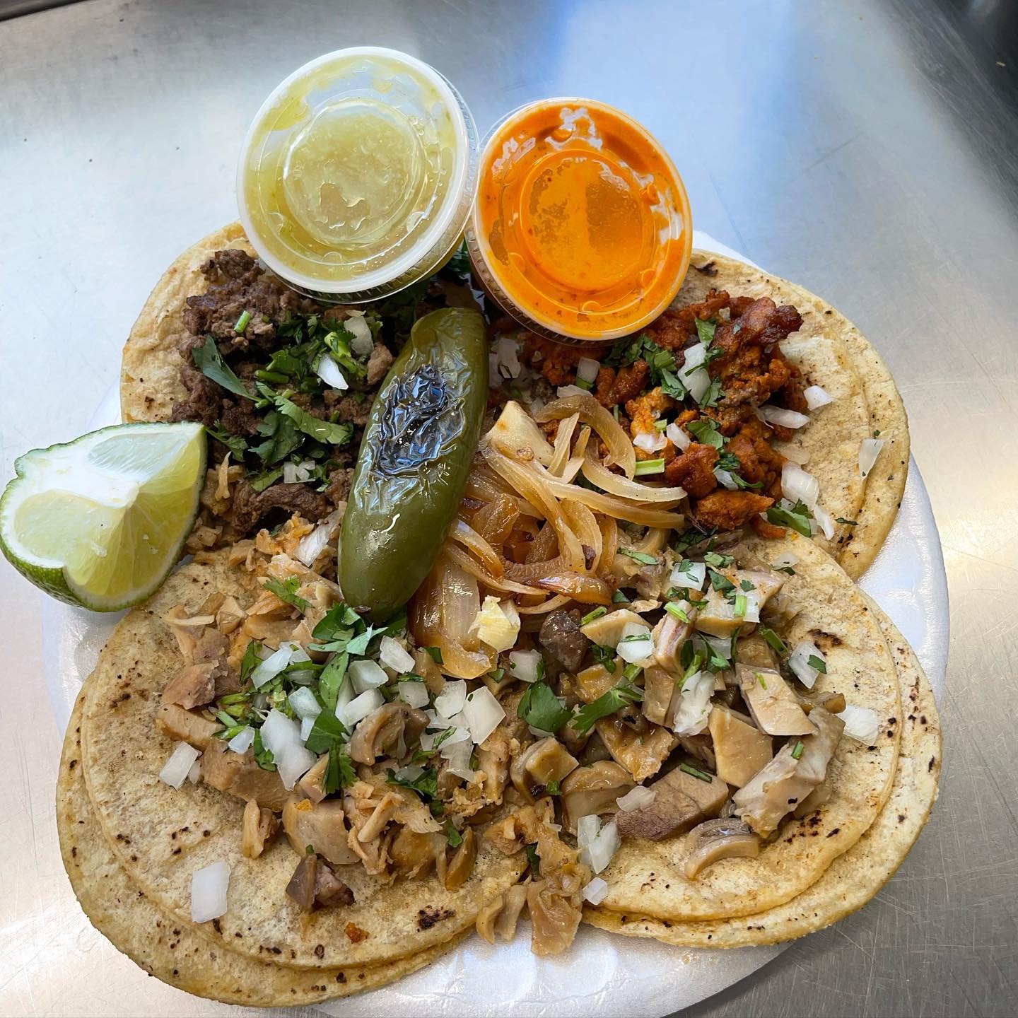 Tacos topped with meat, onions, and cilantro