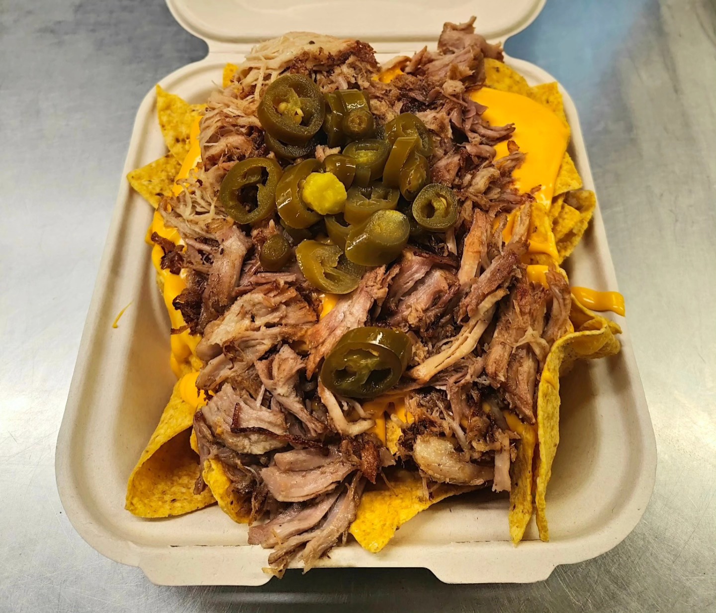 Pulled pork nachos with jalapeños and melted cheese